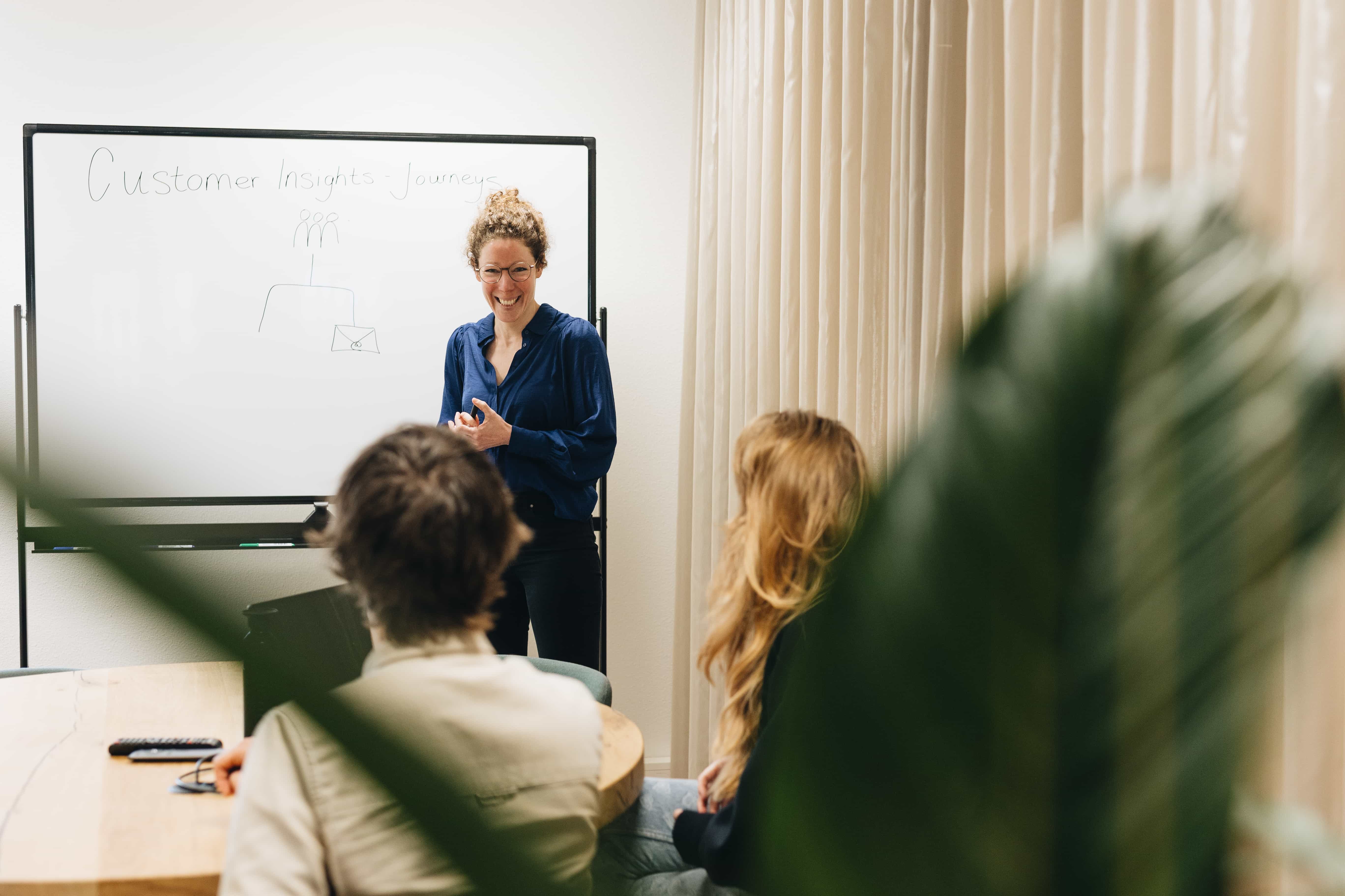 Twee personen in een kantoor bij een whiteboard. Zakelijke samenwerking en brainstormsessie in een moderne werkruimte
